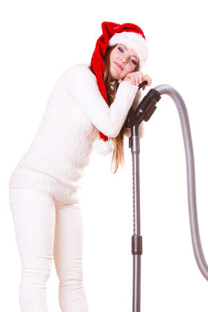 Woman vacuuming the house. Funny girl in santa helper hat with vacuum cleaner. Christmas time and housework concept.の写真素材