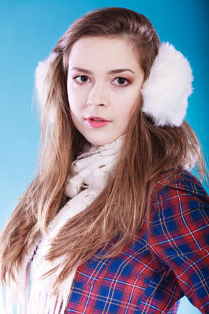 Portrait of pretty woman in winter fashion. White earmuff, cold time.の写真素材