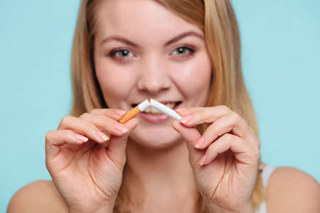 Smilling pretty girl breake down cigarette. Winning with addicted nicotine problems in young age. Quitting from addiction concept.の写真素材