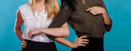 Friendship without ethnic borders. Two women caucasian and african holding hands.の写真素材