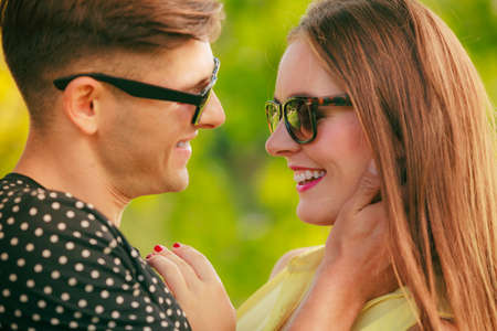 Love and happiness. Young happy couple lovers wearing sunglasses dating in summer park outdoor.の写真素材