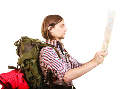 Man tourist backpacker reading map on trip. Young guy hiker searching looking for direction guide....
