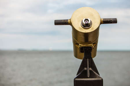 watching sea ocean trought binoculars telescope on a turistic tower. travel and tourismの写真素材