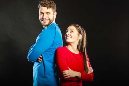 Portrait of smiling woman and man posing in studio on black. Happy joyful couple. Good relationship.の写真素材
