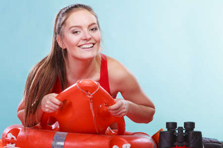Happy lifeguard lying on rescue tube buoy and ring lifebuoy. Joyful woman girl having fun. Accident prevention and rescue.の写真素材