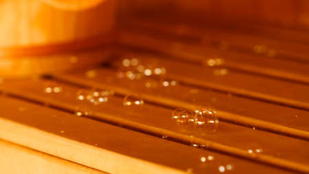 Relax and spa concept. Soap bubbles on wooden bench background in sauna room.の写真素材