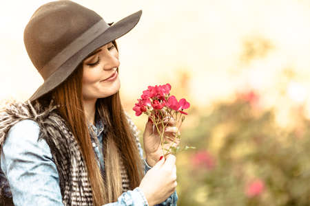 Relax and gardening. Lovely cute young woman spending time in garden. Cheerful beauty girl with pink flowers outdoor.の写真素材