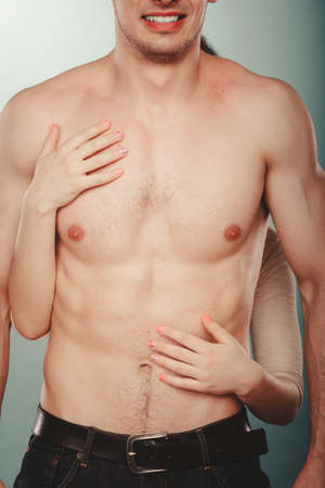 Sexy passionate couple lovers in studio. Woman hands embracing naked nude man. Love and passion.の写真素材