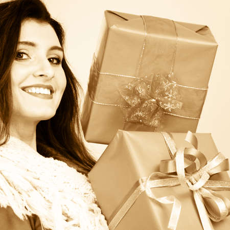 Pretty attractive latin woman holding big boxes gift. Birthday anniversary christmas concept. Sepia...