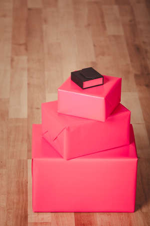 Helping and giving concept. Three red gifts boxes presents and one little black gift box present...
