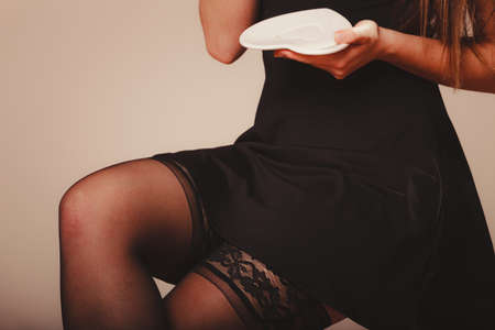 Elegant part body woman in black holding coffee white heart shaped saucer plate.の写真素材