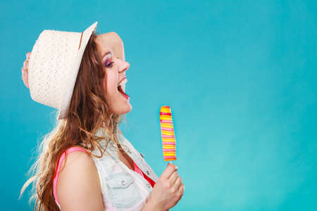 Summer vacation happiness concept. Smiling joyful and cheerful woman fashionable female model eating...