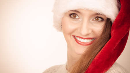 Christmas time. Young latin woman wearing santa claus hat portrait. Studio shot text areaの写真素材