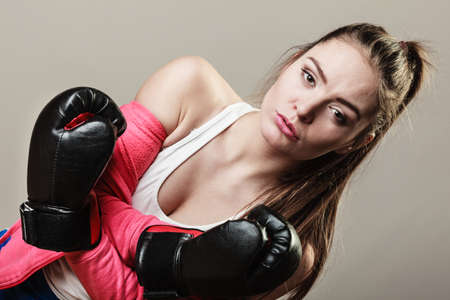 Training, boxing and exercises. Seductive women. Lifestyle concept. Fit girl with gloves on grey background in studio.の写真素材