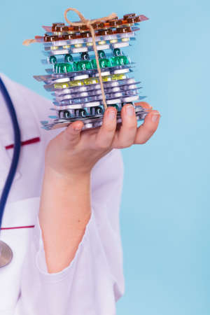 Dietitian nutritionist woman holding diet weight loss tablets pills. Slimming and dieting. Health care.の写真素材