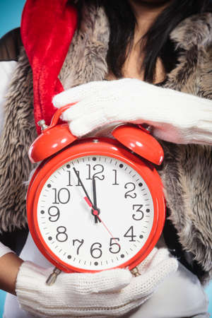 Closeup of woman girl holding alarm clock. Christmas time season concept.の写真素材