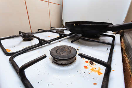 Housework, hygiene and cleaning concept. Dirt at home. Dirty filthy gas stove with used kitchen...