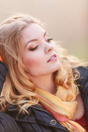 Portrait of pretty fashionable woman in fall forest park. Happy gorgeous blonde young girl in jacket. Autumn winter fashion.の写真素材