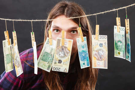 Riches and fortune. Young happy man with a lot of money on black background. Winning the lottery...