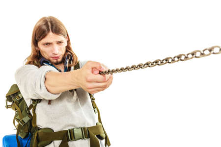 Backpacker mountaineer hiking climbing rock mountain. Young man scrambling mountaineering. Active lifestyle adventure. Isolated on white background.の写真素材