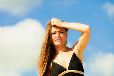 Little shocked woman on beach. Long hair girl model blue sky.の写真素材