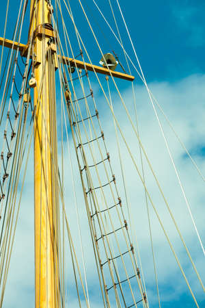 Yachting. Sailboat view of different parts of yacht. Mast against blue summer sky