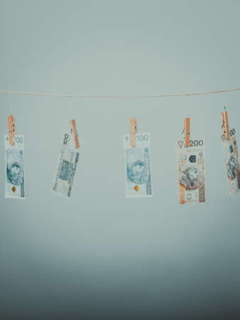 Banknotes cash money hang on laundry line on gray grey background.