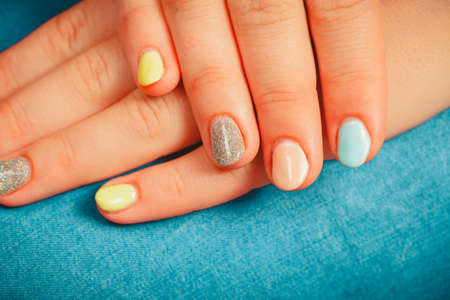 Close up of woman girl hands with color nail polish. Manicure cosmetic beauty treatment.