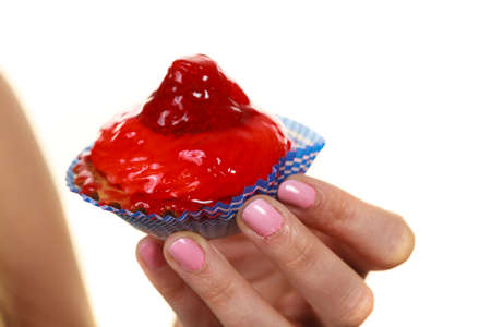 Sweet food indulging and fattening concept. Delicious tasty sweet cake cupcake in human hand isolated on whiteの写真素材