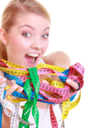 Time for diet slimming weight loss. Health care healthy lifestyle. Sport fitness woman fit girl holding a lot of colorful measure tapes isolated on whiteの写真素材