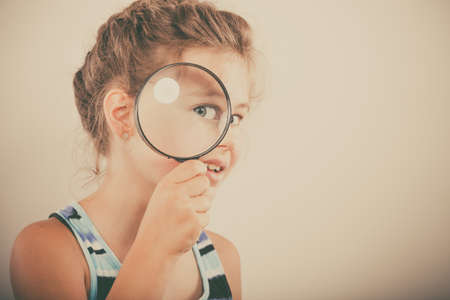 Sweet cute little girl kid looking through magnifying glass.の写真素材