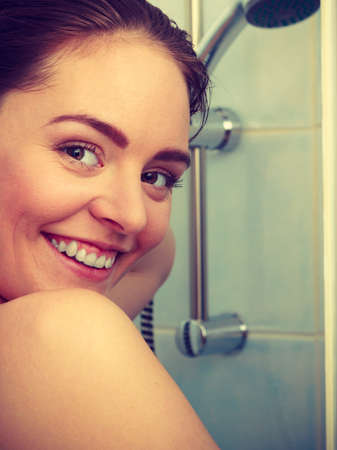 Girl showering in shower cabin cubicle enclosure. Young woman taking care of hygiene in bathroom.の写真素材
