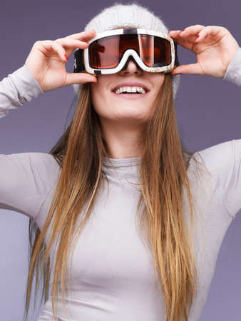 Attractive woman in winter cap gray sports thermal underwear for skiing training ski googles studio shot on blue.の写真素材
