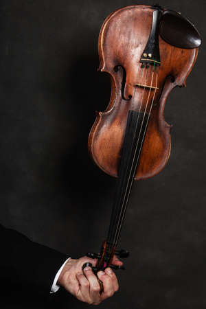 Art. Closeup of old wooden violin stringed instrument on dark gray. Classical music.