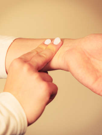 Medicine health care. Female hand checking pulse on wrist closeup.の写真素材