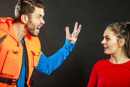 Angry upset man lifeguard shouting screaming at woman lifesaver. Conflict.