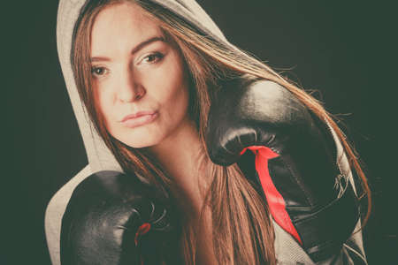 Boxing and feminity. Sport woman hooded with black box glovesの写真素材