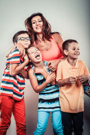 Portrait of happy smiling family sweet cute kids little girl, boys and mother woman in studio....