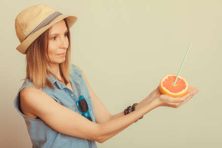 happy glad woman tourist in straw hat with sunglasses and grapefruit citrus fruit. healthy diet food. summer vacation holidays concept.の写真素材