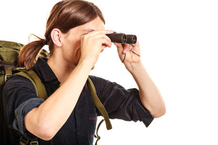 Man tourist backpacker looking through binoculars. Young guy hiker backpacking. Summer vacation...