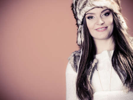 Beauty and fashion of women. Wintertime. Portrait of attractive young girl in fur winter cap hat. Studio shot.の写真素材