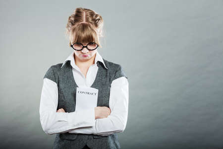 Business documents legal concept - closeup skeptical unhappy businesswoman holding contract in hands. Negative human emotion face expression feeling reactionの写真素材