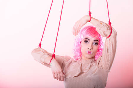 Young woman girl stylized like marionette puppet on stringの写真素材