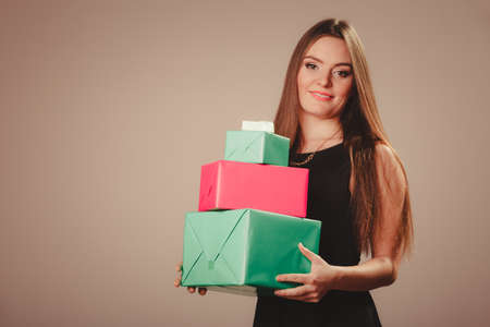 Helping and giving concept. Beauty gorgeous attractive woman in black holding boxes presents gifts...