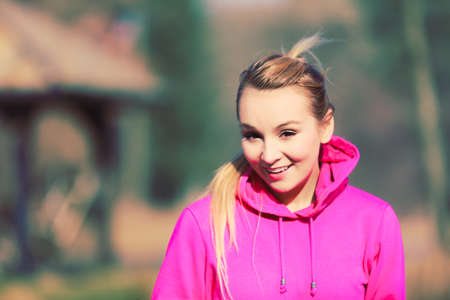 Warm dressed young smiling girl under autumntime in park. Taking care about healthy lifestyle and slim figure. Active sporting leisure.の写真素材
