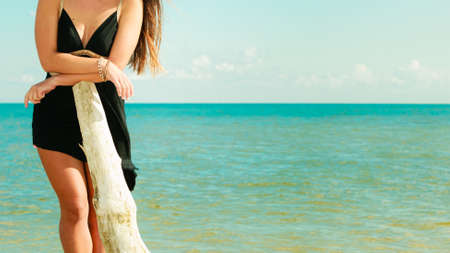 Holidays, vacation travel and freedom concept. Part of female body, attractive sensual girl beauty long hair on seaside. Young pretty tanned woman in summer dress relaxing on the sea coastの写真素材