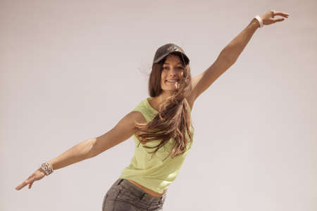 Portrait of pretty casual carefree teenager girl in cap relaxing outdoor. Urban street fashion and...