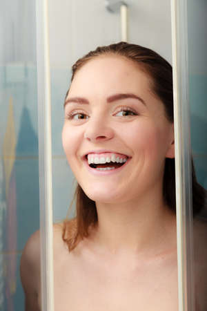 Girl taking shower. Young woman taking care of hygiene in bathroom.