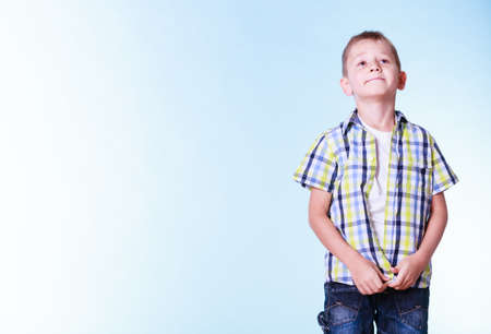 Fitting garment for kids independence. Boys stand alone fastening shirt. Prepare for adolescence trying new clothes.の写真素材