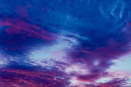 Romantic and dramatic cloud formation on dusk sky. blue and purple cold landscape with sunlight.の写真素材